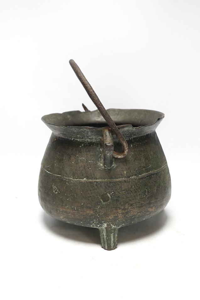A 16th / 17th century bronze cauldron, 21.5cm tall with handle down. Condition - poor, losses and repairs to rim and body